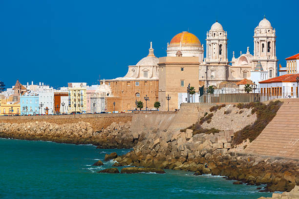 Beach and Cathedral in Cadiz, Andalusia, Spain Playa de la Santamaria beach and Cathedral de Santa Cruz in the morning in Cadiz, Andalusia, Spain cádiz photos stock pictures, royalty-free photos & images