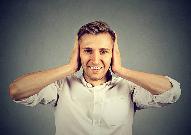 istock Handsome happy young man covering his ears 621710034