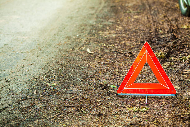 istock Breakdown of car. Red warning triangle sign on road 621710286