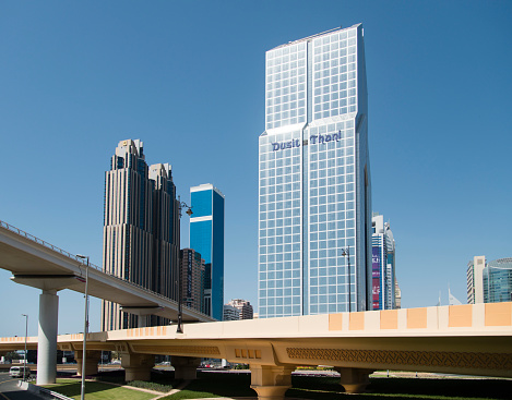 Dubai, United Arab Emirates - March 25, 2016: Dusit Thani hotel and other skyscrapers in downtown Dubai seen during a hot day. In front some bridge highways are showing.