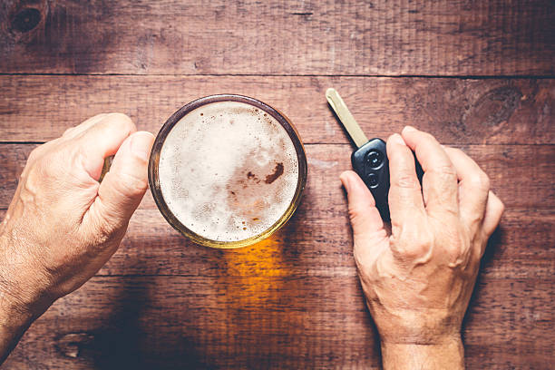 Man hand drinking beer and holding car keys stock photo