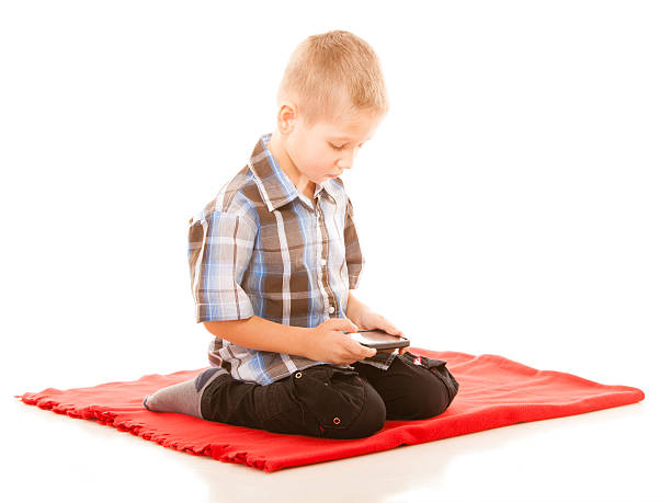istock Little boy playing games on smartphone 621711624