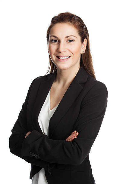 Satisfied businesswoman with arms crossed smiling An attractive brunette businesswoman wearing a black suit and white shirt, standing with her arms crossed against white background. blazer jacket stock pictures, royalty-free photos & images