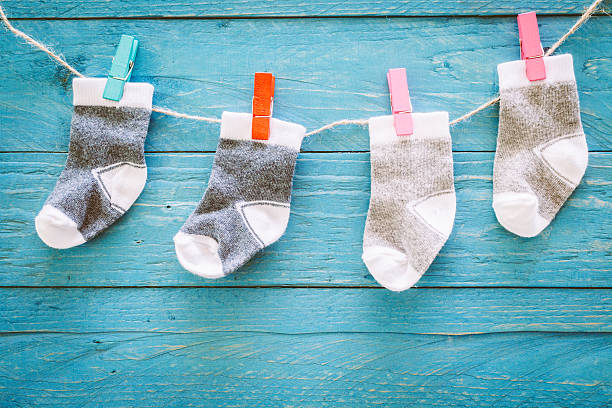 istock Baby socks on a wooden background 621715248