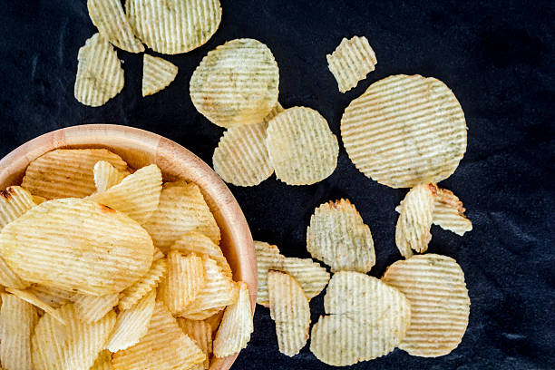 istock Crispy potato chips in a wooden bowl 621716646
