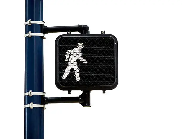 Person walking symbol on lighted pedestrian street crossing sign mounted to a pole isolated on white