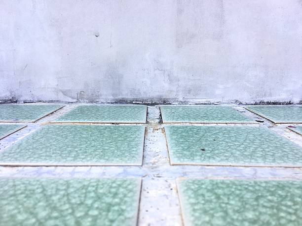 istock Grungy concrete wall and Green tiled floor room as background 621717810