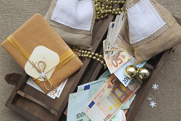 Wooden box with presents Wooden box full of Christmas presents and euros euro bill in a christmas ornament stock pictures, royalty-free photos & images