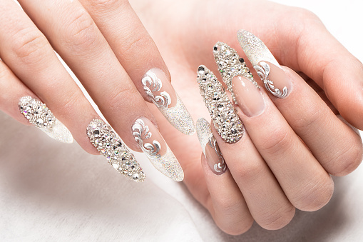 Beautifil wedding manicure for the bride in gentle tones with rhinestone. Nail Design. Close-up.