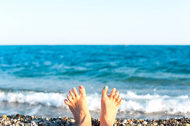 divertimento estivo! piedi sulla spiaggia. sfondo onde blu dell'oceano. - sole of foot human foot women humor foto e immagini stock
