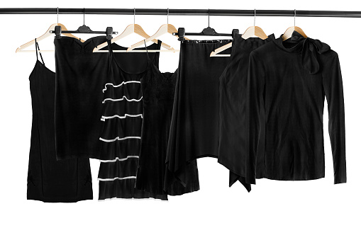 Set of black clothes on wooden clothes racks isolated over white