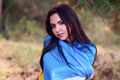 Beautiful brunette model posing in park with  flag of Ukraine
