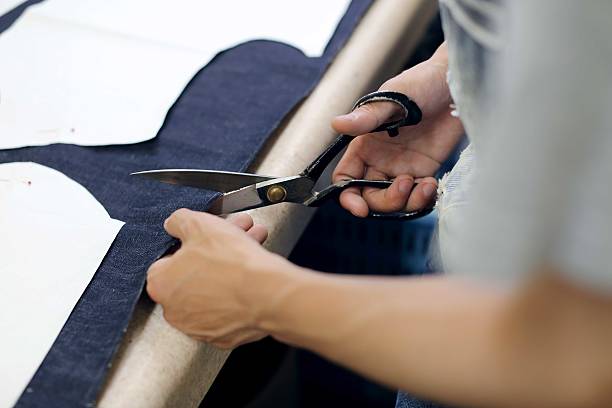 The tailor who cuts denim with scissors a tailor who cuts denim with scissors okayama prefecture stock pictures, royalty-free photos & images