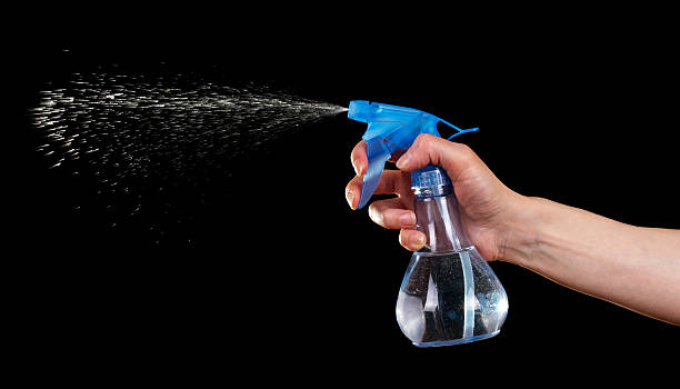 istock The female hand with plastic bottle spray isolated on black. 621726354