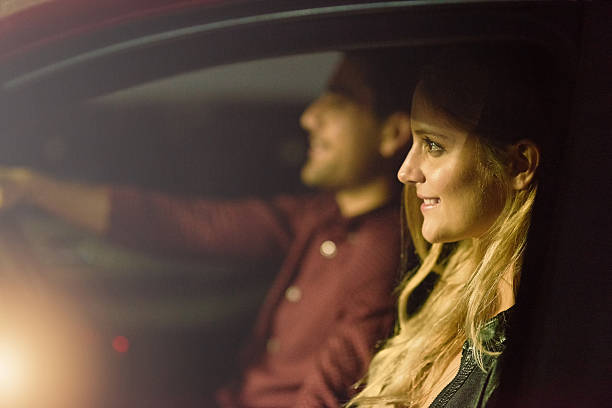 On their first date, he picked her up Shot of a young couple traveling in a car together at night couple driving at night stock pictures, royalty-free photos & images