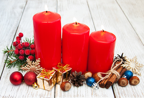 Christmas decoration with candle and fir branch on red background