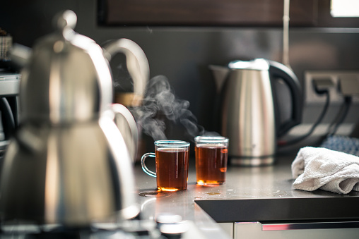 Two cups of hot morning tea in the kitchen.