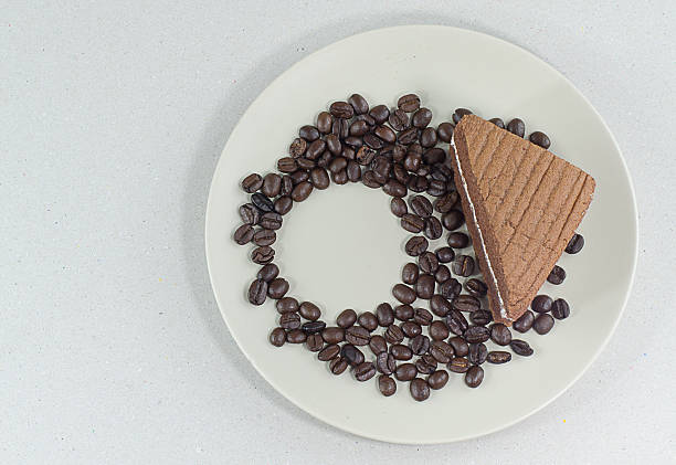 coffee bean with slice of chocolate cake on white background - latté hot chocolate hot drink indulgence imagens e fotografias de stock