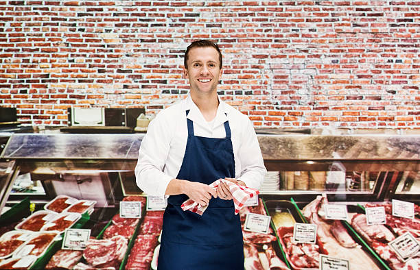 Smiling butcher standing in shop
