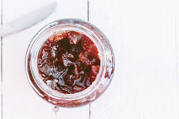 istock Strawberry jam in a jar on wooden table 621731454