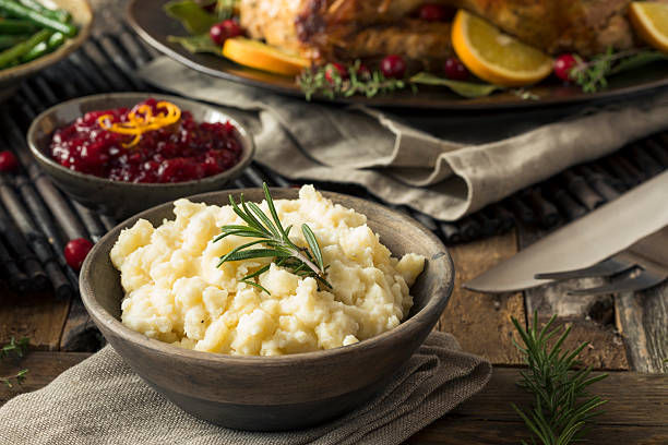 Homemade Thanksgiving Mashed Potatoes Homemade Thanksgiving Mashed Potatoes with butter and Rosemary gravy stock pictures, royalty-free photos & images