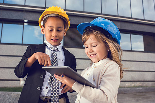 istock Smiling little engineers working together on digital tablet. 621732058