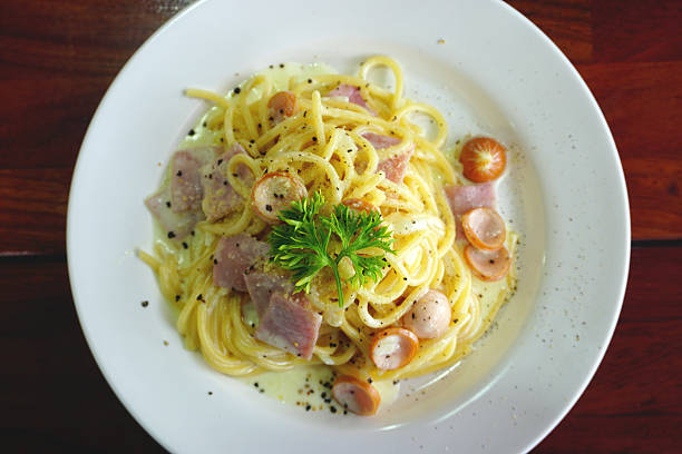 spaghetti carbonara au jambon et saucisse - lard close up pasta eggs photos et images de collection