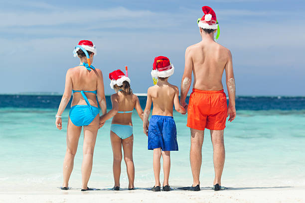 istock back view family santa hats beach 621815752