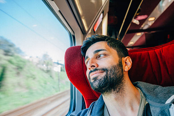 jeune homme voyageant en train - bus inside of people train photos et images de collection