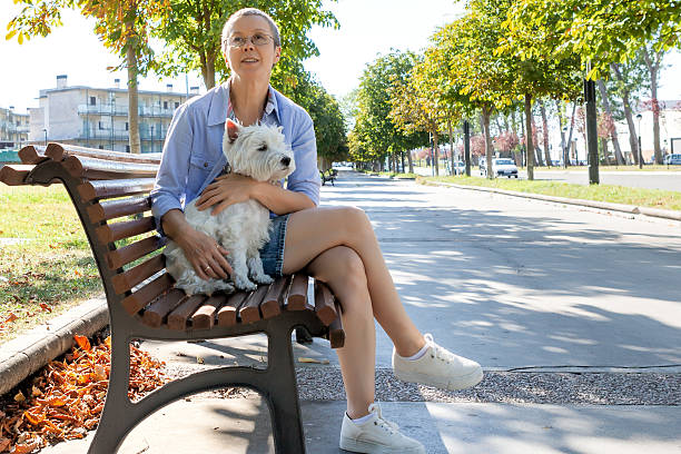 istock Mature woman with dog on the bench 621817608