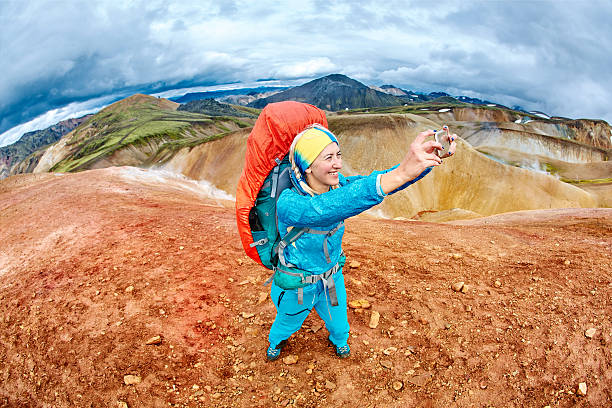 woman hiker photographer taking selfie on the rhyolite mountains background in Iceland