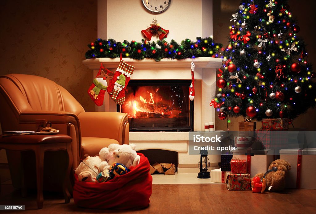 Christmas Tree and Christmas gift boxes in interior with fireplace Christmas Tree and Christmas gift boxes in the interior with a fireplace. Christmas living room with fireplace and armchair Christmas Stock Photo