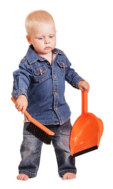 istock Cute little boy standing holding dustpan and brush isolated. 621819126