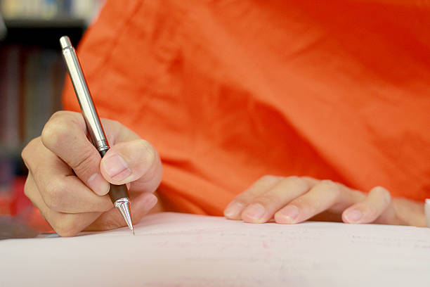 istock Monk's Hand writing in a book with the pencil 621819192