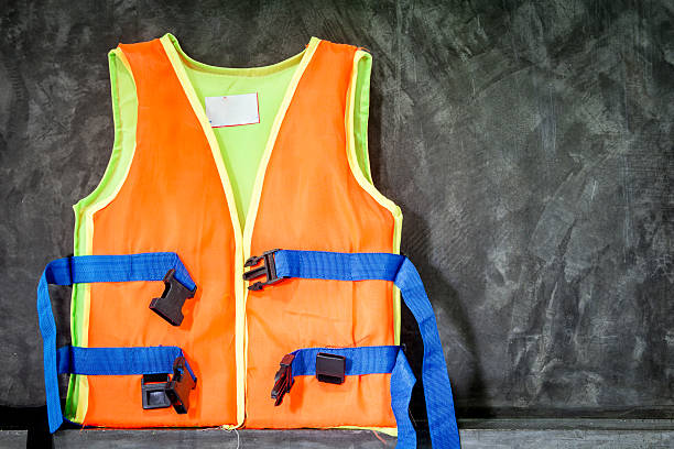 istock Orange life jackets on stone background 621819598