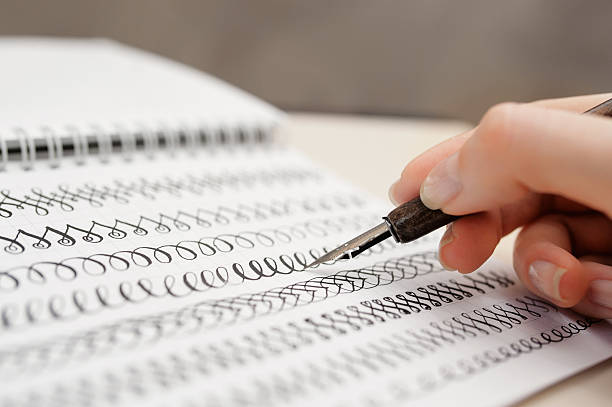 istock woman hand with pen for calligraphy writing in a notebook 621821456