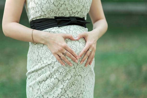 istock Woman's hands on pregnant belly 621821702