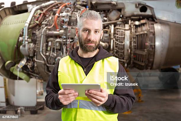 Aircraft Mechnic Using A Digital Tablet In A Hangar Stock Photo - Download Image Now
