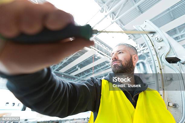 Aircraft Mechnic Repairing Airplane In A Hangar Stock Photo - Download Image Now - Adult, Air Vehicle, Airplane