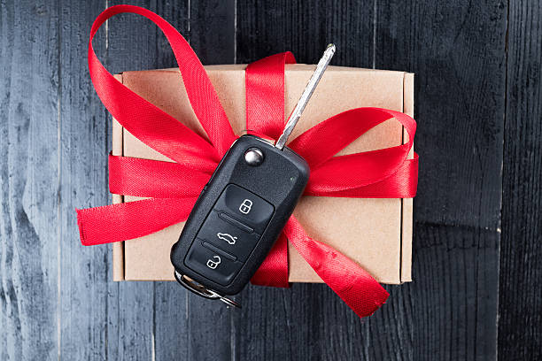 istock Car key on a paper box with red ribbon bow. 621823860