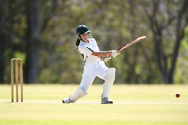 Female Cricketer Batting A young girl plays a shot while batting in a game of cricket cricket stock pictures, royalty-free photos & images