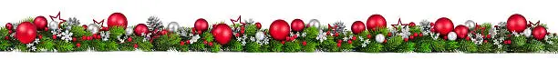 Extra wide Christmas border with fir branches, red and silver baubles, pine cones and other ornaments, isolated on white