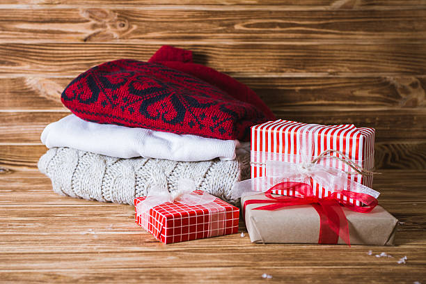 istock Christmas gift boxes and sweater on a wooden background 621827254