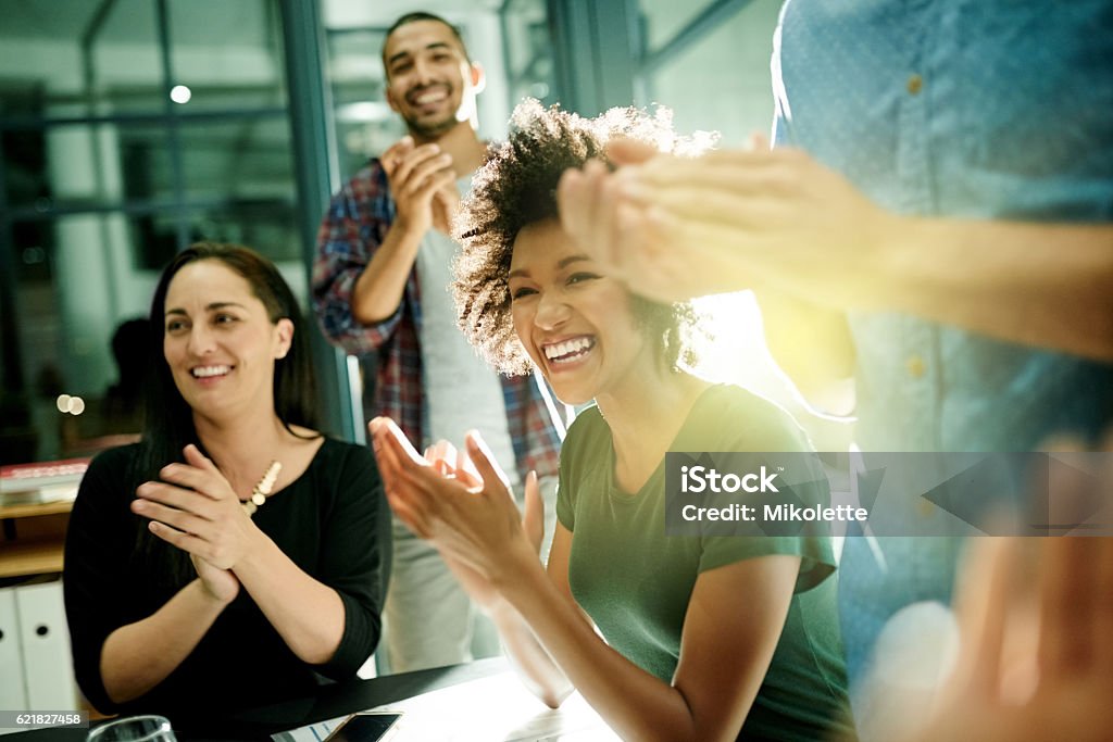 Celebrating our achievements together Shot of a team of creative businesspeople applauding an achievement  while working late in the boardroom Happiness Stock Photo