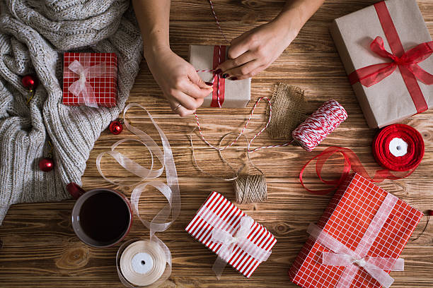 istock Female hands wrapping Christmas presents in paper 621827854