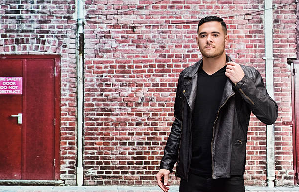 istock Man in front of brick wall outdoors 621828262