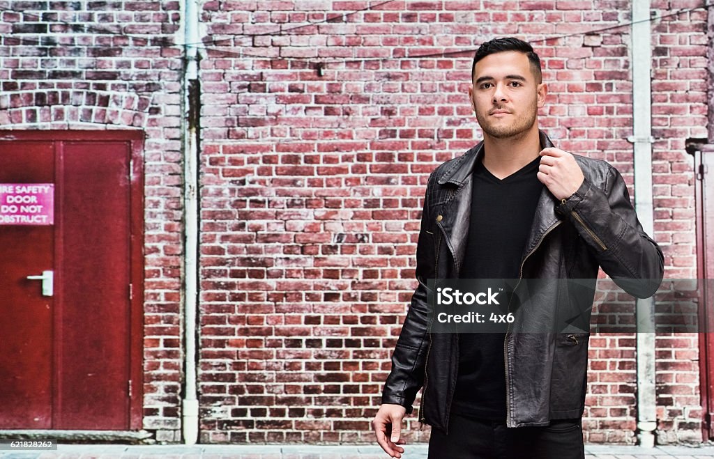 Man in front of brick wall outdoors Adult Stock Photo