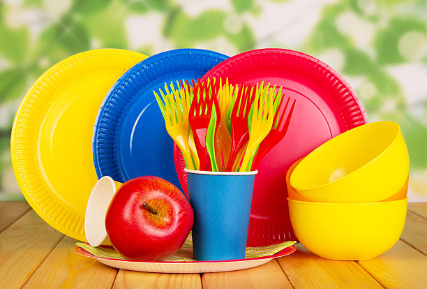 istock Bright disposable plates, cups, plastic bowls, forks on abstract green. 621828656