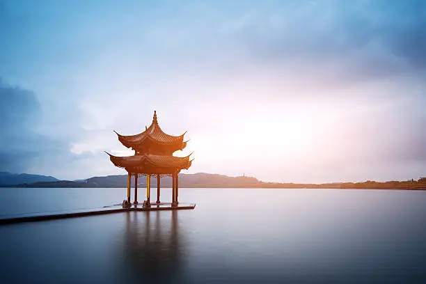 chinese ancient pavilion with sunset at the west lake in hangzhou