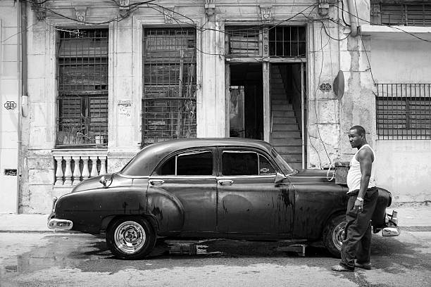 uomo che lava auto d'epoca a l'avana, cuba - chevrolet havana cuba 1950s style foto e immagini stock